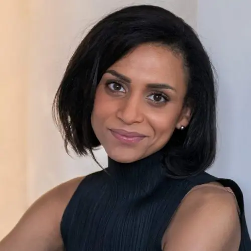 An image of the Black writer Rachel Long. She has chin length black hair and is wearing a sleeveless black pleated black top with a high neck.